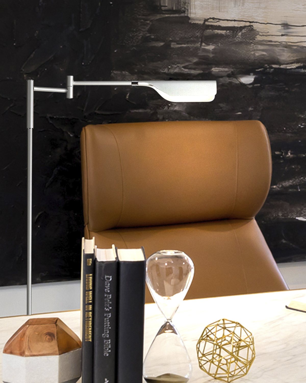 Silver Brightech Leaf floor lamp with its swing arm extended over a desk and a leather office chair