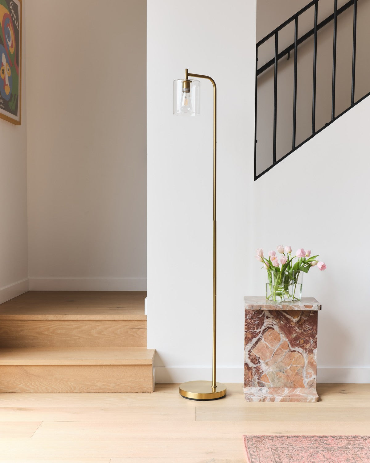 Brass Brightech Elizabeth floor lamp with a clear glass shade beside a staircase and a marble side table
