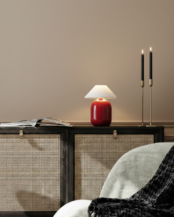 Red Brightech Ren portable lamp with a cream shade on a cane sideboard