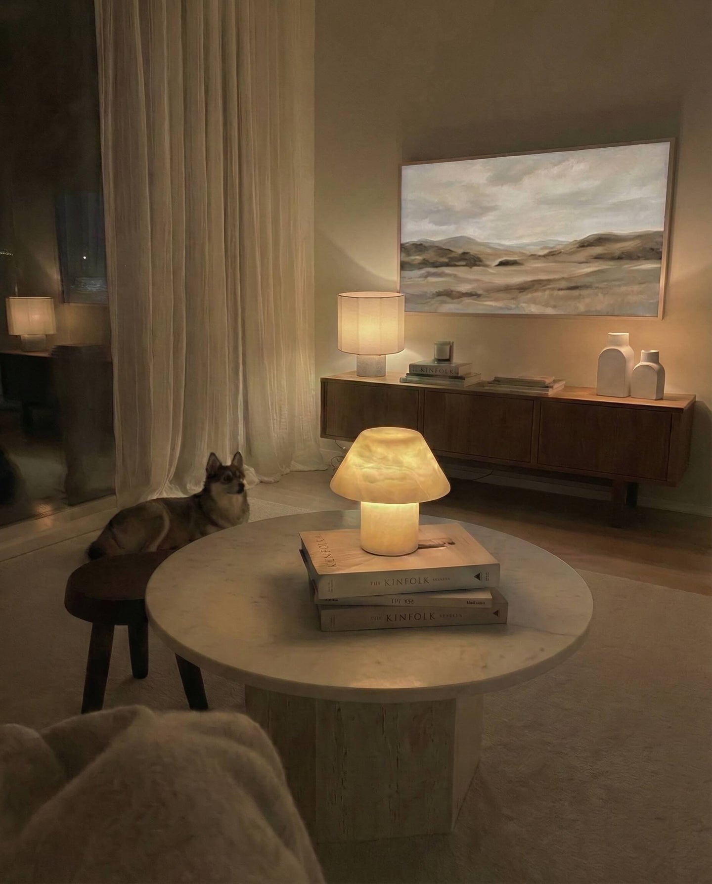 Modern living room with a cat, lamp, and wall art