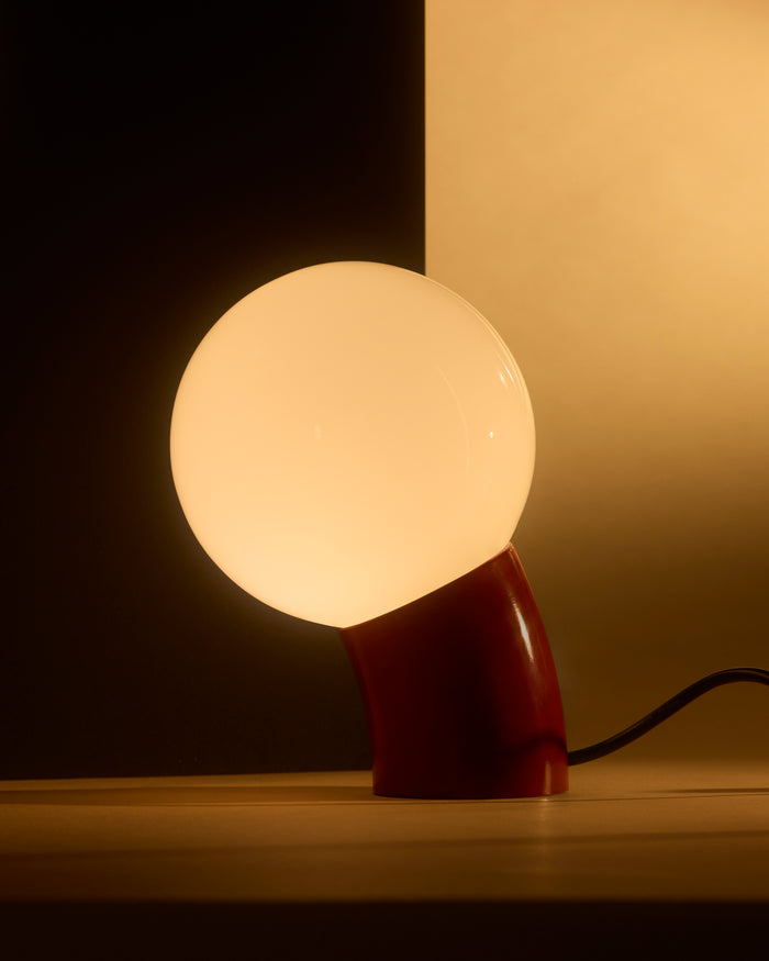 Brightech Vino table lamp in red with a glowing glass globe