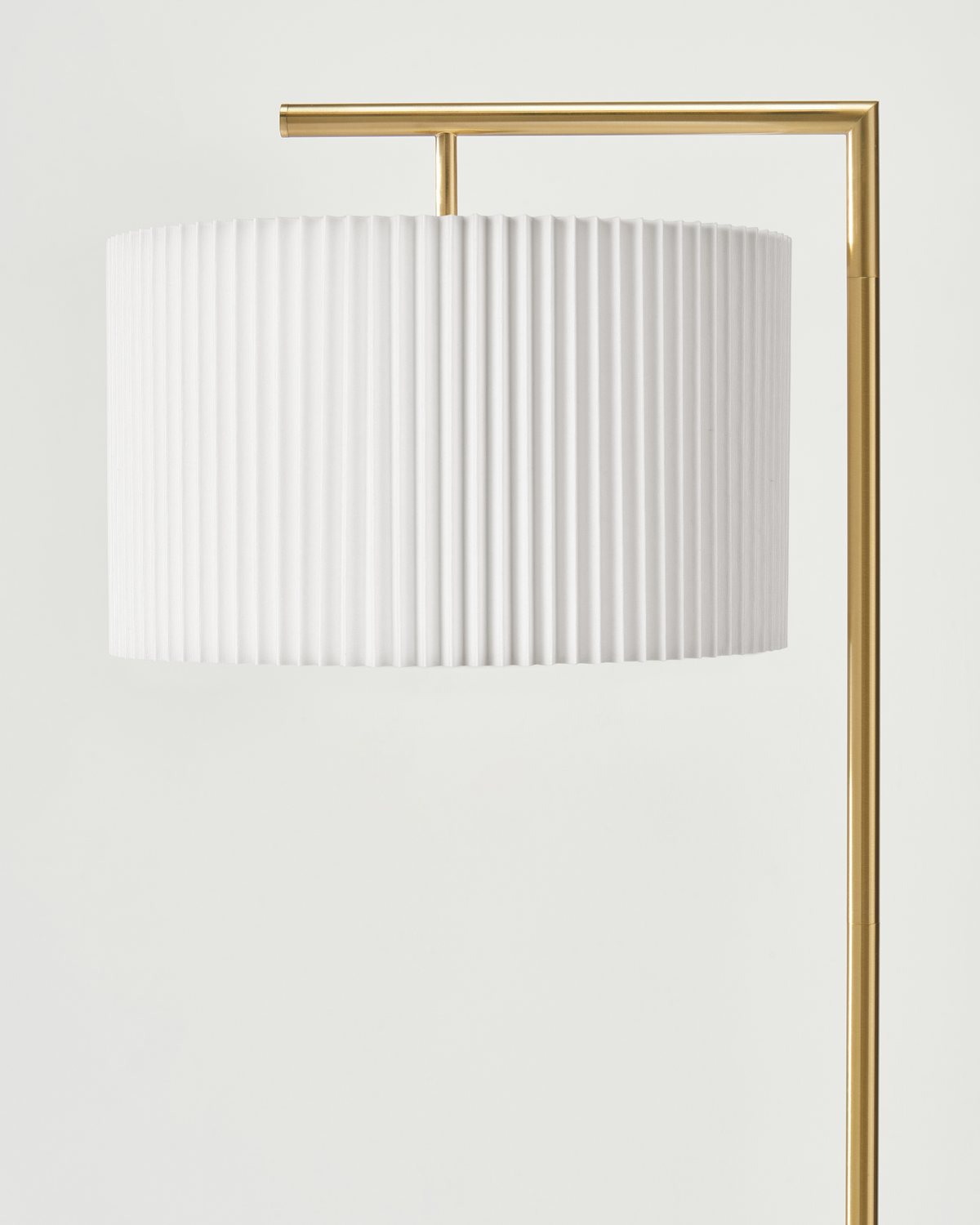 Close-up of the pleated white shade and brass frame on the Brightech Montage Modern floor lamp