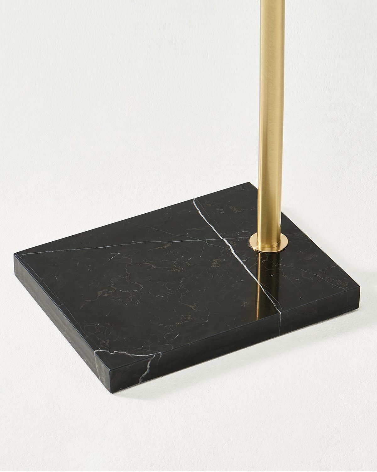 Close-up of the rectangular black marble base of the Brightech Logan arc floor lamp with its brass pole