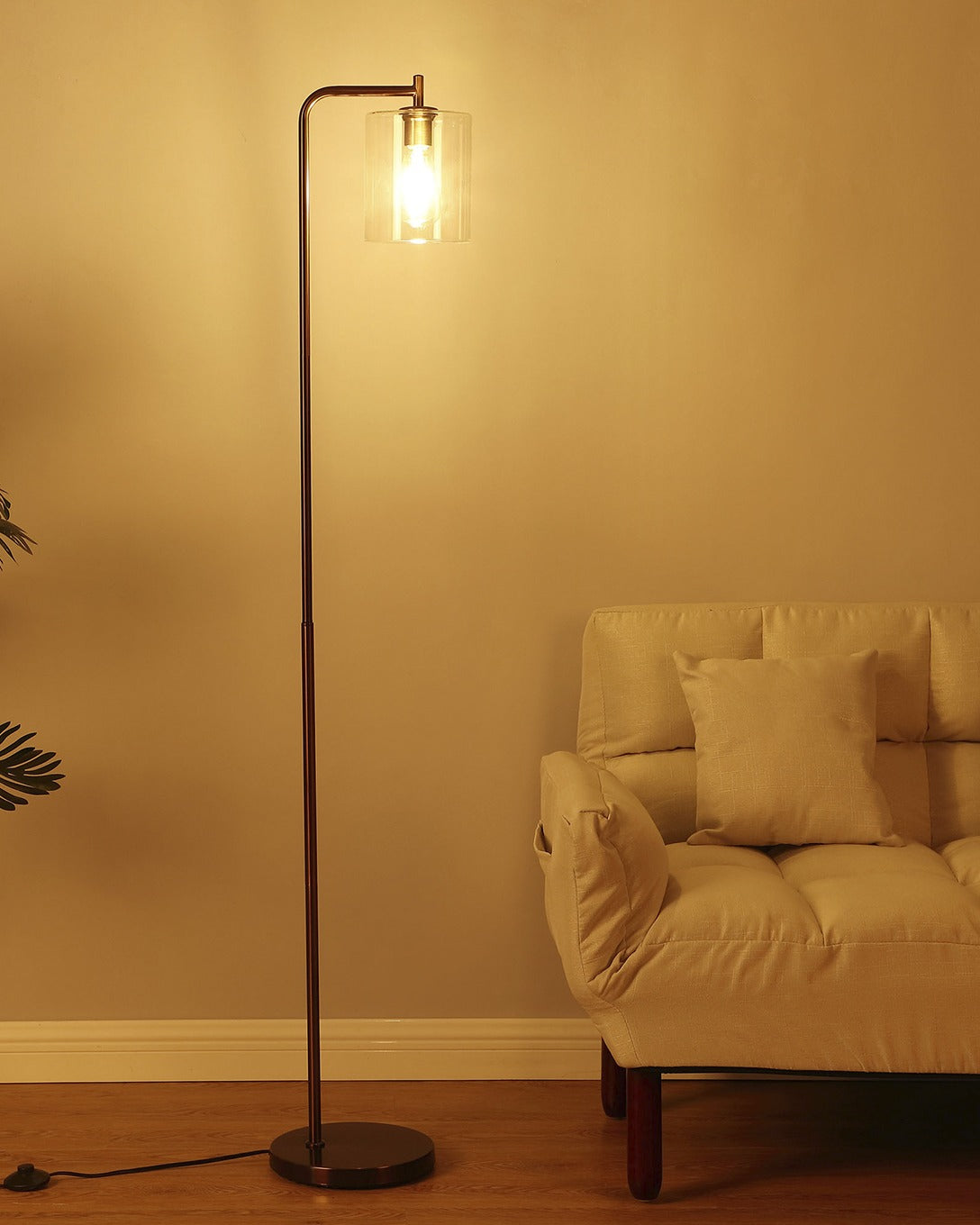 Bronze Brightech Elizabeth floor lamp with a clear glass shade filling a living room with warm light